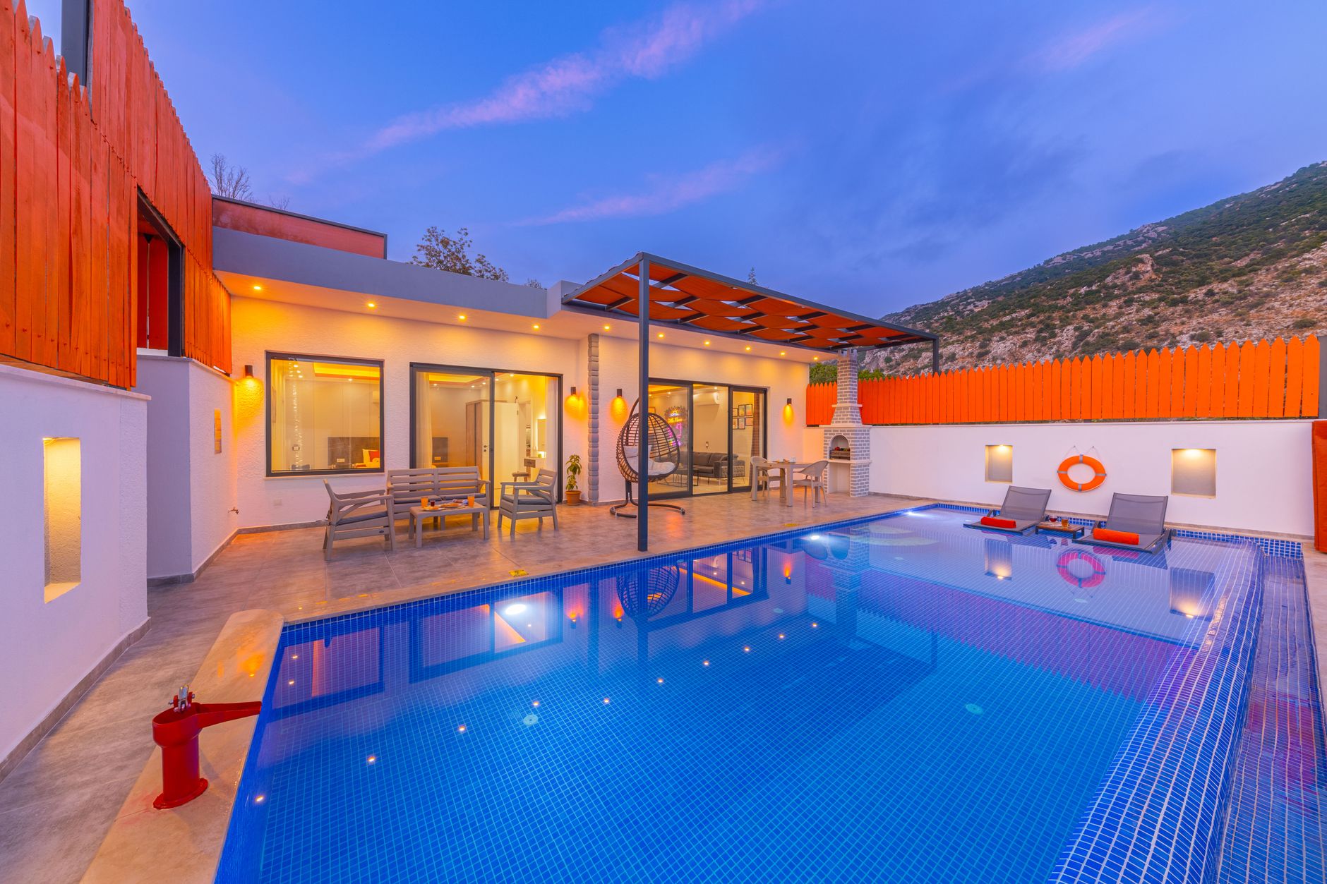 Elegant modern resort featuring a stylish swimming pool under a vibrant twilight sky.